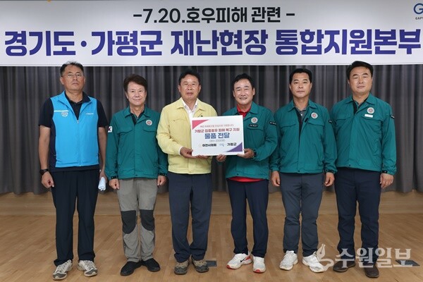 박명서 이천시의회 의장(오른쪽 세번째)이 서태원 가평군수(왼쪽 세번째)에게 피해복구 구호물품 생수 2000병을 전달한 뒤 기념촬영을 하고 있다. (사진=가평군)