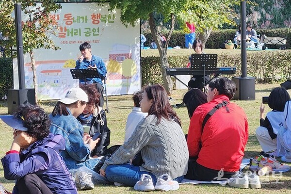 관광명소인 수원화성 용연에서 ‘새빛 동행버스킹’ 공연이 열리자 시민들이 자유롭게 감상하고 있다.(사진=수원시)