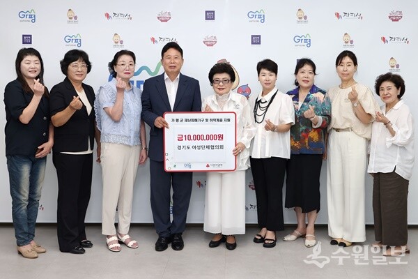이금자 경기도여성단체협의회장(가운데)이 서태원 가평군수(왼쪽 네번째)에게 성금 1천만원을 전달한뒤 관계자들과 함께 기념촬영을 하고 있다. (사진=가평군)
