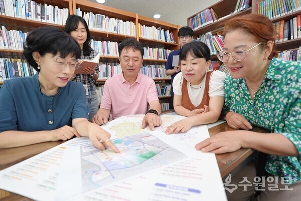 수원시 서둔동 주민들이 우리동네 자치계획을 들여다보며 회의를 하고 있다.(사진=수원시)
