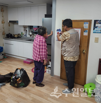 구리시의 한 어르신이 관계공무원으로부터 비상벨 사용법을 듣고 있다. (사진=구리시)