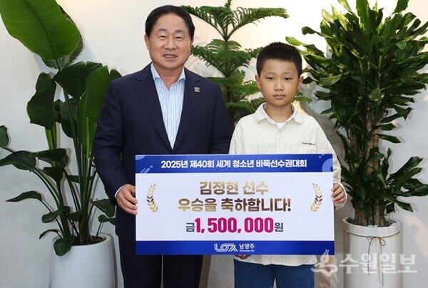 주광덕 남양주시장(왼쪽)이 남양주 출신 바둑 영재 김정현 선수에게 포상금을 전달한 뒤 기념촬영을 하고 있다. (사진=남양주시)