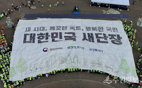 14-3. 22일 대한민국 새단장 캠페인 행사 참석자들이 대형 현수막을 머리 위로 넘기며 ‘대한민국 새단장’ 결의 퍼포먼스를 하고 있다. (사진=화성시)