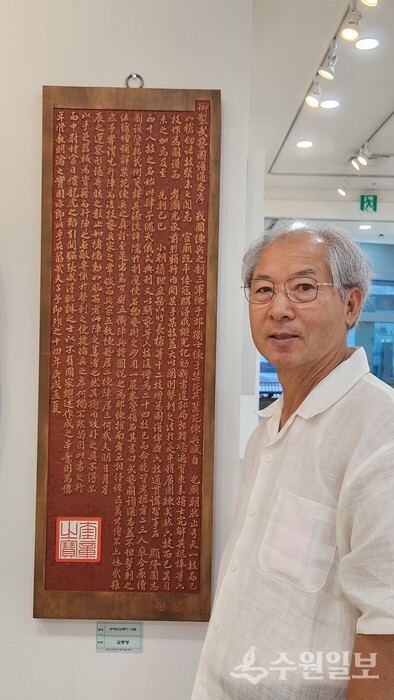 김충영 본보 편집위원이 ‘무예도보통지 서문’ 출품작 앞에서 포즈를 취하고 있다. (사진=수원일보)
