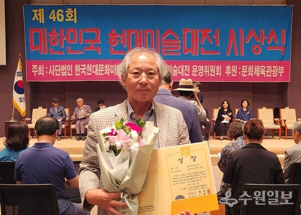 김충영 수원일보 편집위원이 23일 프레스센터에서 개최된 '제46회 대한민국 현대미술대전' 시상식에서 서각부문 최우수상을 받은 뒤 기념촬영을 하고 있다. (사진=수원일보)