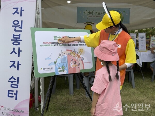봉사자들이 탄소중립과 4R 운동의 필요성을 담은 보드를 시민들에게 설명하고 있다. (사진=신천지자원봉사단 구리남양주지부)