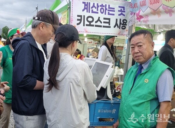 안정섭 구리시새마을회장(오른쪽)이 구리시 코스모스 축제장에서 시민들을 상대로 키오스크 운영을 안내하고 있다. (사진=구리시새마을회)