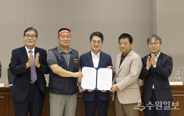 1일 오전 김동연 경기도지사(가운데)가 경기지방노동위원회에서 열린 경기도 버스 노사 협상장을 방문, 김기성 경기도버스운송사업조합이사장(오른쪽 두번째), 이기천 경기지역자동차노동조합 위원장(왼쪽 두번째)와 협약서를 들고 기념촬영을 하고 있다. (사진=경기도)