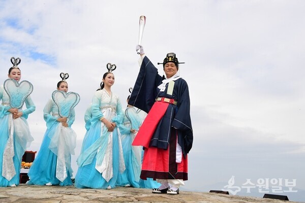 박용철 강화군수(오른쪽)가 마니산 참성단에서 채화한 성화를 ‘제106회 전국체육대회’가 열리는  부산광역시에 전달하기 앞서 높이 들어 올리고 있다. (사진=강화군)