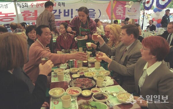 1999년 '제36회 수원화성문화제 갈비축제'에서 주한외국대사와 국제자매도시 대표단과 함께 한 심재덕 시장(왼쪽)이 잔을 권하고 있다. (사진=이용창 화성연구회 이사)