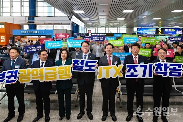 14일 청주공항에서 '중부권 광역급행철도(JTX) 조기착공 촉구 결의대회'에 참석한 7개 도시 관계자들이 건의문에 서명을 한 후 기념촬영을 하고 있다. (사진=용인시)