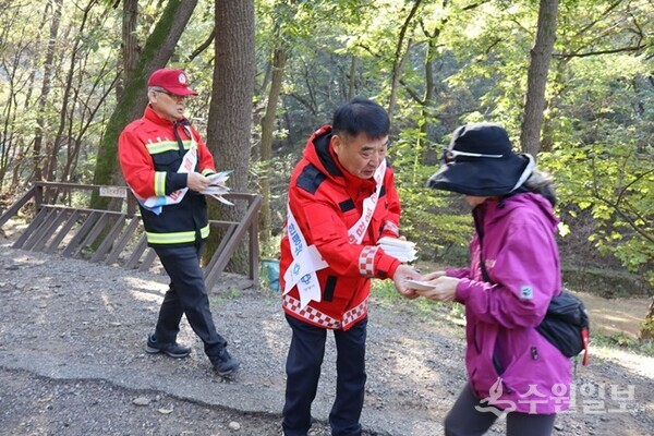 황인섭 안양시 동안구청장(가운데)이 등산객들에게 홍보물을 배포하며 산림 내 안전 수칙을 전달하고 있다. (사진=안양시 동안구)