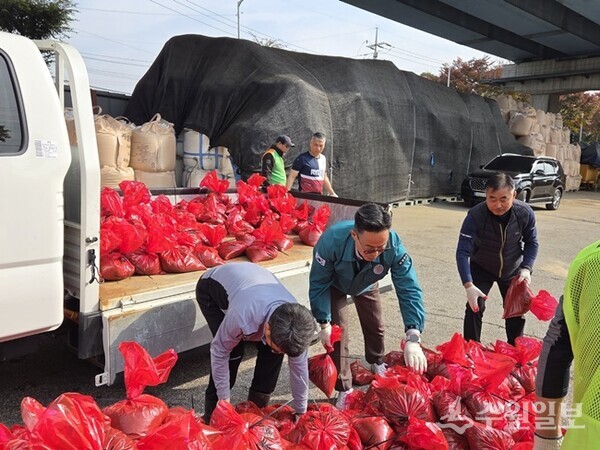 이기복 센터장(가운데)이 자율방재단 등 20여명과 함께 제설용 모래주머니를 제작하고 있다. (사진=남양주시 다산행정복지센터)[