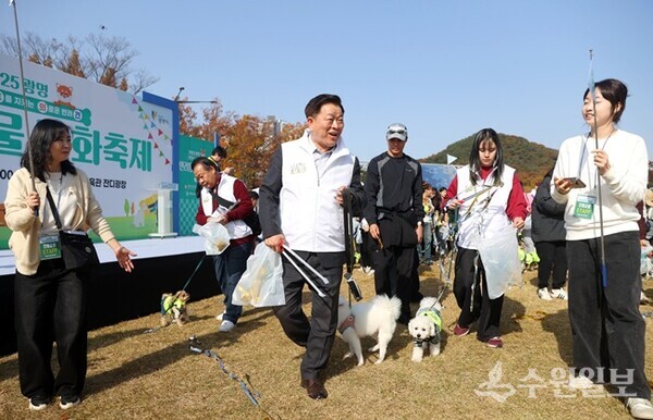 박승원 광명시장이 '2025 광명 반려동물 문화축제'에서 '기후반려견'과 함께 펫플로깅(반려견과 산책하며 쓰레기 줍기)을 하고 있다. (사진=광명시)