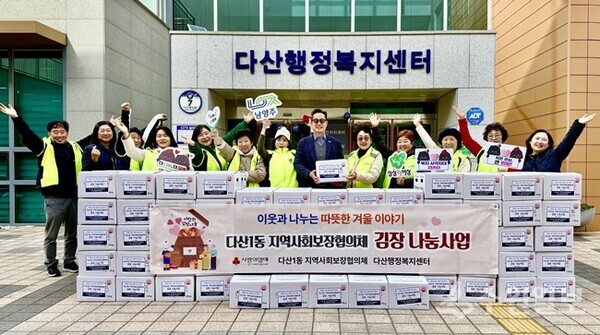 이기복 다산행정복지센터장(오른쪽 여섯번째)이 다산1동 지역사회보장협의체와 김장김치를 전달하며 기념촬영을 하고 있다. (사진=다산행정복지센터)