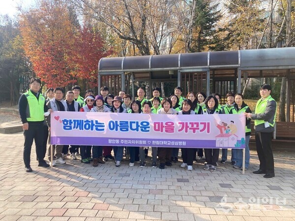 안양시 동안구 평안동 주민자치위원회와 한림대학교성심병원이 합동 환경정화 활동을 벌인 뒤 기념촬영을 하고 있다. (사진=안양시)