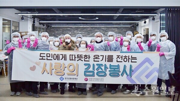 '사랑의 김장봉사'에 나선 경기신용보증재단 시석중 이사장(가운데)과 임직원들이 기념촬영을 하고 있다. (사진=경기신보)