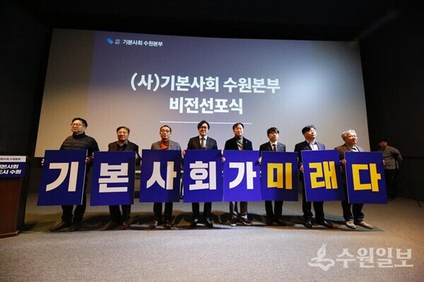 권혁우 (사)기본사회 수원본부 상임대표(왼쪽 네번째), 김준혁 국회의원(오른쪽 네번째)을 비롯한 내빈들이 '기본사회가 미래다'라는 피켓을 둘고 기념촬영을 하고 있다. (사진=기본사회 수원본부) 