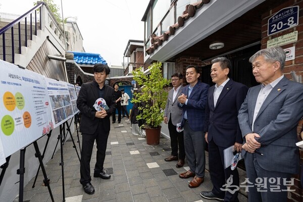수원시와 한국보훈복지의료공단이 수원지역 독립유공자 후손의 집수리를 지원한 새빛하우스 앞에서 이재준시장(오른쪽에서 3번째)등 관계자들이 사업 설명을 듣고 있다.(사진=수원시)