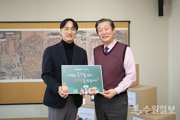 오영균 수원문화재단 대표이사(왼쪽)가 김철수 수원지역아동센터연합회장과 기부물품 증정식을 가지면서 기념촬영을 하고 있다. (사진=수원문화재단)