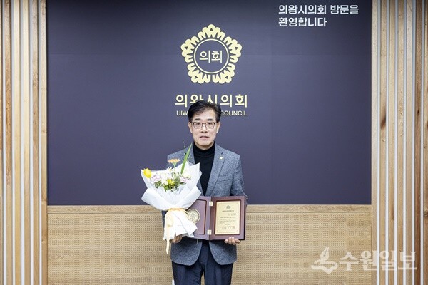 김학기 의왕시의회 의장이 대한민국시군자치구의회의장협의회에서 선정한 ‘대한민국지방의정봉사상’을 들고 기념촬영을 하고 있다. (사진=의왕시의회)