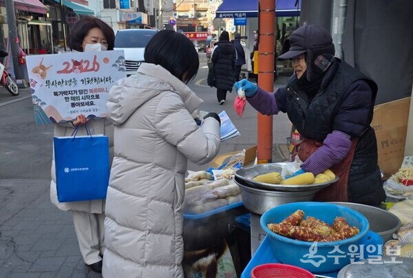 신천지 구리교회 봉사자들이 구리시 구리시장에서 상인들에게 설맞이 복주머니를 전달하고 있다. (사진=신천지 서울야고보지파 구리교회)