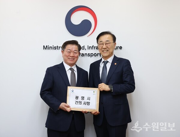 박승원 광명시장(왼쪽)이 김윤덕 국토교통부 장관에게 월곶판교선 학온역 일반 열차 정차 등 광명시 지역 현안이 담긴 건의 사항을 전달한 뒤 기념촬영을 하고 있다. (사진=광명시)