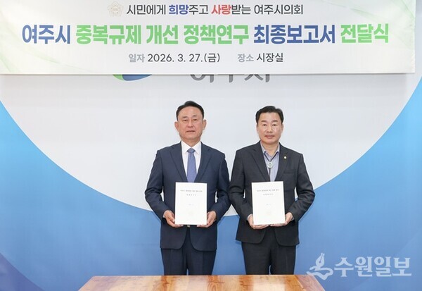 박두형 여주시의회 의장(오른쪽)이 이충우 여주시장에게 2025년 추진한 ‘여주시 중복규제 개선 정책연구’ 보고서를 전달한 뒤 기념촬영을 하고 있다. (사진=여주시의회)