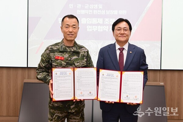 박용철(오른쪽) 인천 강화군수와 최영길 해병대 제2사단장이 31일 2사단에서 민간인 통제선 이북지역 주간 대면 검문 체계 폐지를 위한 업무협약을 체결한 뒤 기념촬영을 하고 있다. (사진=강화군)