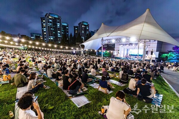 시민들이 제1야외음악당 잔디밭에 앉아 수원시립합창단 잔디밭음악회를 감상하고 있다. (사진=수원시)