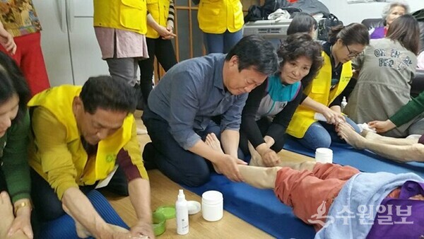 신동화 구리시장 예비후보(가운데)가 어르신의 발을 주무르고 있다. (사진=신동화 구리시장 예비후보)