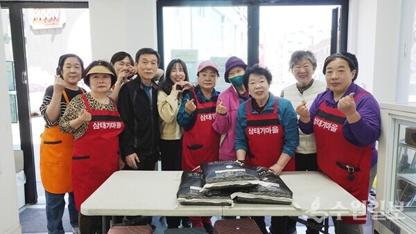 세계평화통일가정연합이 서울 성북구 삼태기마을공동체를 방문해 쌀을 전달한 뒤 기념촬영을 하고 있다. (사진=세계평화통일가정연합)
