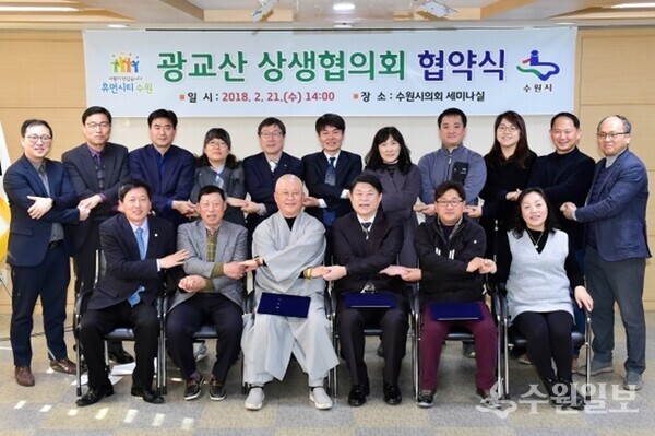 지난 2018년 2월 21일 수원시의회 세미나실에서 가진 ‘광교산 일대 지속 가능한 관리를 위한 상생 협력 협약’ 체결식에서 수원시광교산상생협의회 소속 위원들이 협약 체결 후 기념 촬영을 하고 있다. (사진=수원시)