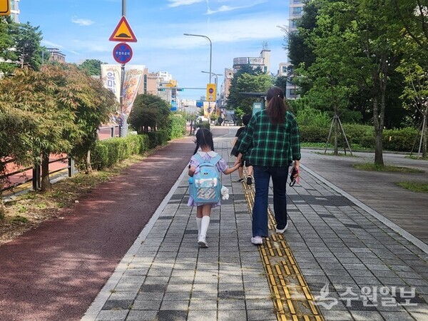 ‘초등 저학년 등하교 동행돌봄 서비스’로 아이와 동행하고 있는 새빛돌보미. (사진=수원시)