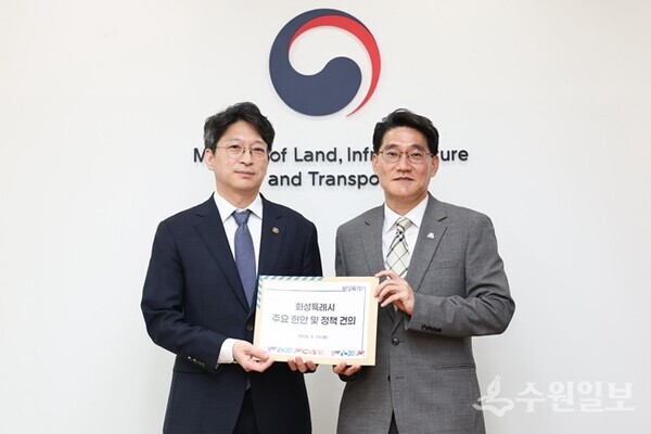 윤성진 화성특례시장 권한대행(오른쪽)이 홍지선 국토교통부 제2차관에게 화성특례시 주요 현안 및 정책 건의서를 전달하고 있다. (사진=화성시)