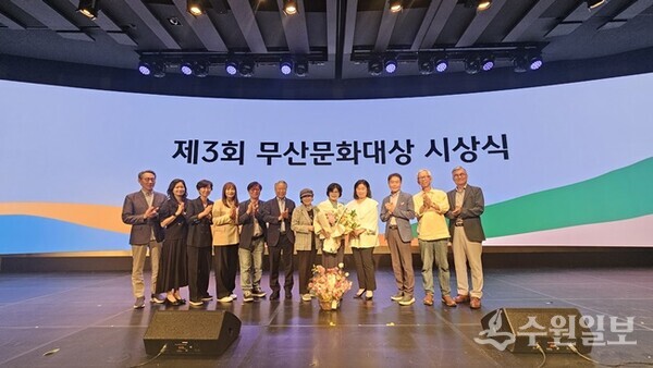 제3회 무산문화대상을 받은 정수자 시인(가운데 꽃다발을 든 사람)이 시상식장에 참석한 사단법인 화성연구회 회원들과 기념 촬영을 하고 있다. (사진=화성연구회)