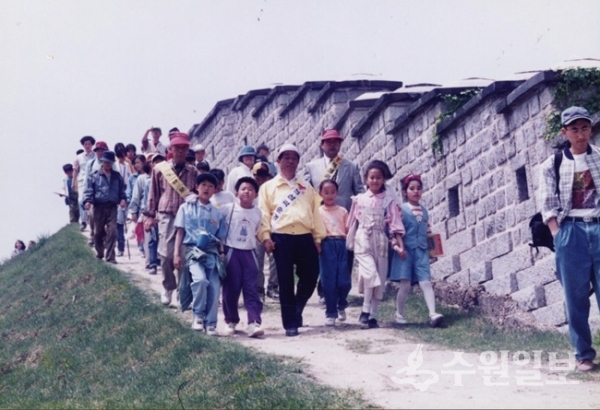 효의 성곽순례 행사에서 어린이들과 함께 화성을 걷고 있는 심재덕 당시 수원문화원장. (사진=수원문화원)