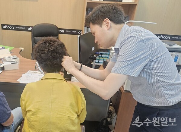 덴마크 오티콘 보청기 남양주점이 어르신을 상대로 보청기를 달아주고 있다. (사진=남양주시)