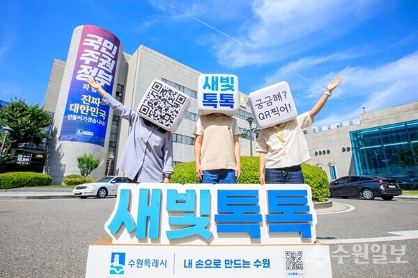 수원시 관계자들이 수원시청 청사 앞에서 새빛톡톡을 홍보하는 사진을 찍고 있다.(사진=수원시)