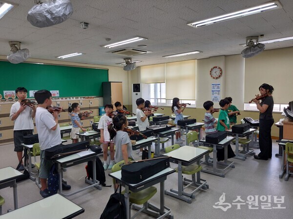 수원 천천초등학교 학생들이 방과후 무료 체험 프로그램에서 바이올린 연주를 배우고 있다. (천천초등학교 제공)