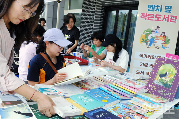 18일 오전 수원시 팔달구새마을문고회 주관으로 팔달구청 앞마당에 마련된 '벤치 옆 작은도서관' 행사에서 구청을 찾은 시민들이 도서대여와 키링만들기를 체험하고 있다. (사진=김기수기자)